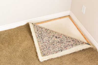 carpet corner pulled back to reveal new carpet padding